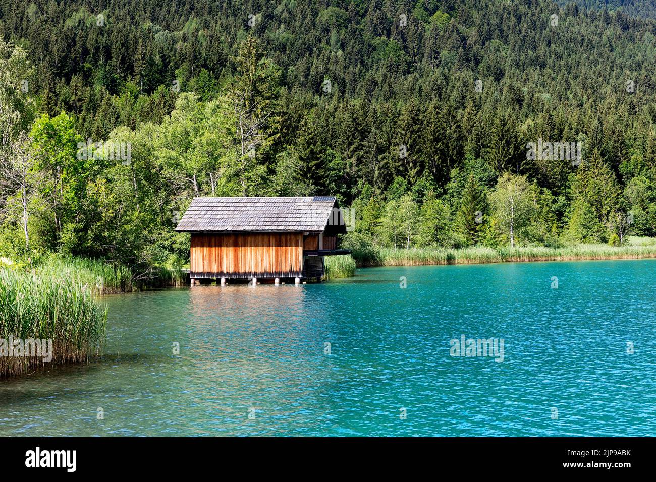 Tradizionale casa di legno o capanna sulla riva di un bellissimo lago Weissensee in carinzia, Austria Foto Stock