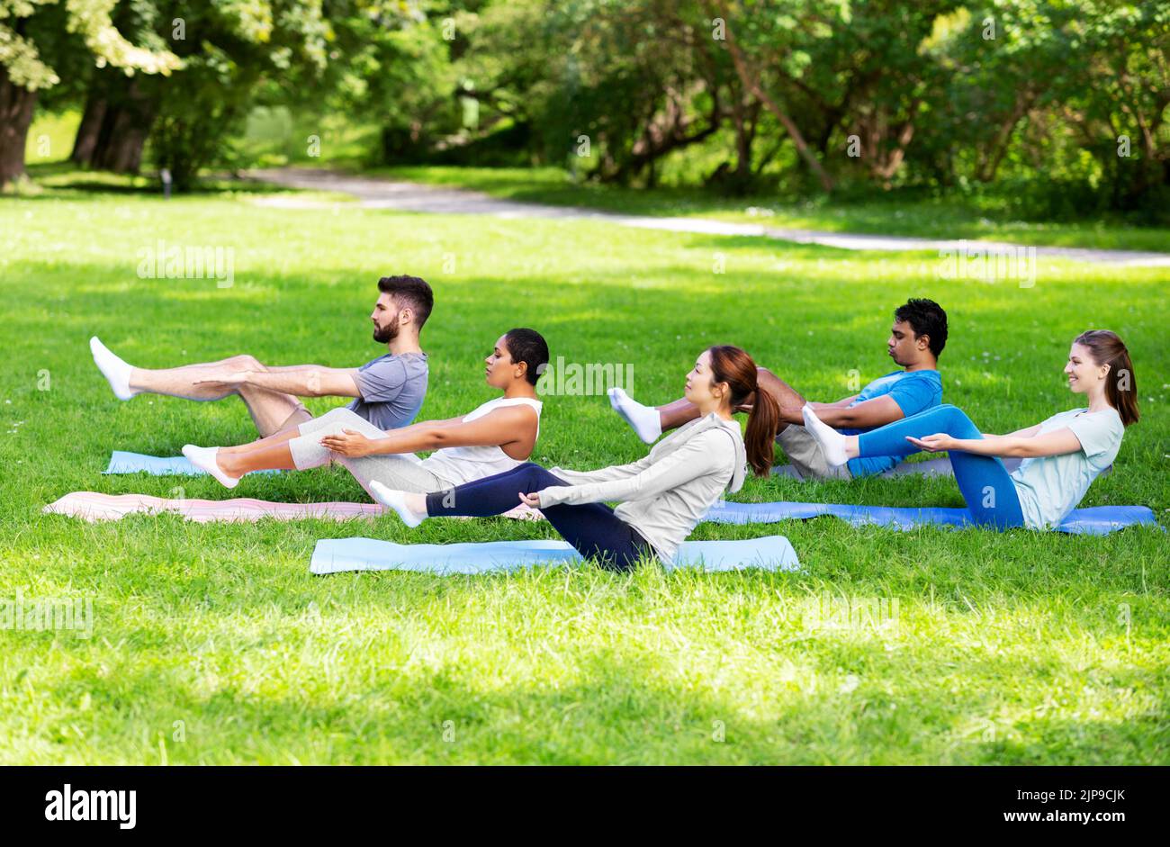 gruppo di persone che fanno yoga al parco estivo Foto Stock