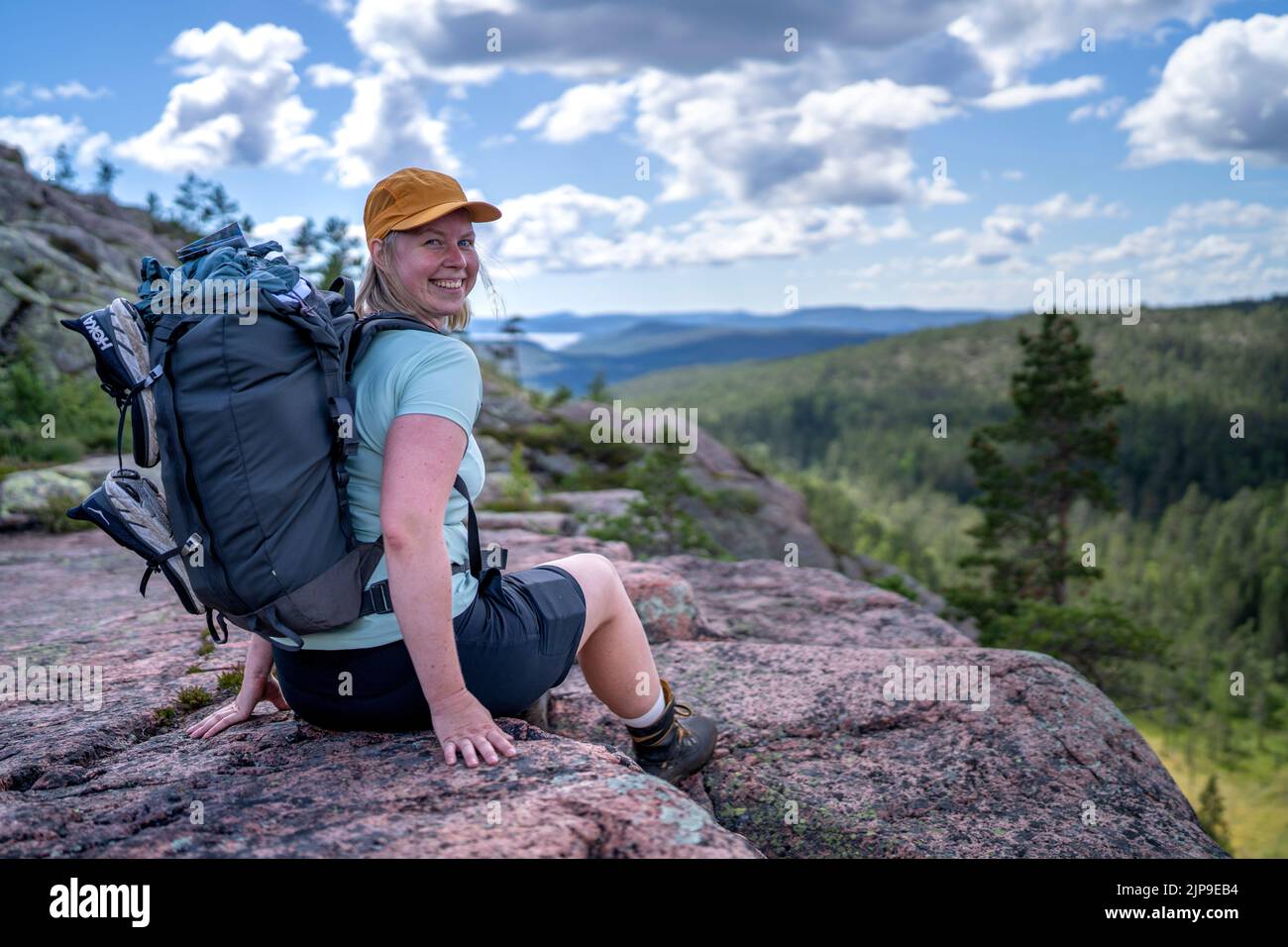 Donna adulta attiva all'aperto caucasica seduta con abiti da trekking Foto Stock