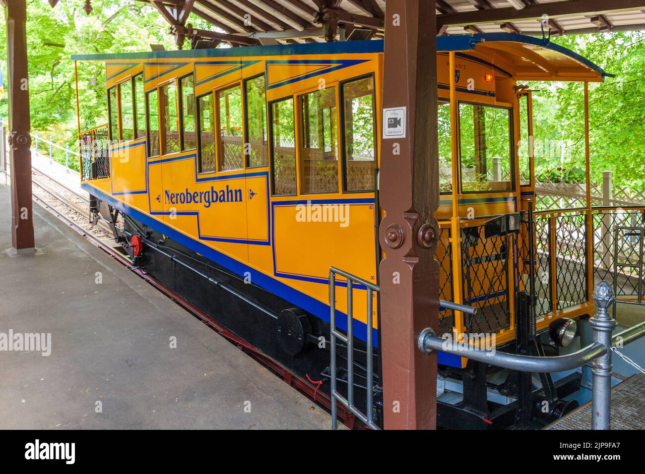Grande vista ravvicinata di una carrozza della funicolare di Nerobergbahn con il suo caratteristico colore giallo nella stazione inferiore di Wiesbaden, Germania. Il... Foto Stock