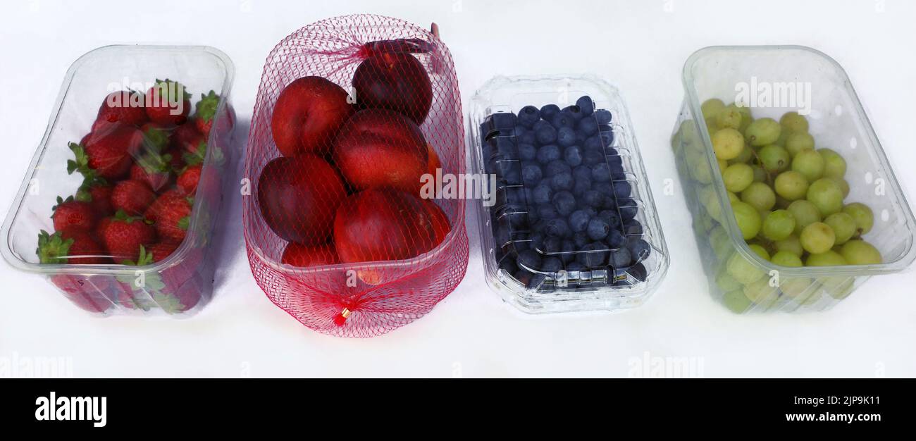 Fragole, nettarine, mirtilli e uva dal supermercato. Tutti confezionati in plastica. Otteniamo molto spreco di plastica. Foto Stock