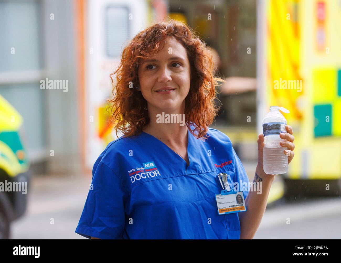 Un medico dell'NHS si raffredda con un drink d'acqua durante una pausa presso un London Hospital. L'NHS è sotto pressione per il sottofinanziamento e la pressione sul lavoro. Foto Stock
