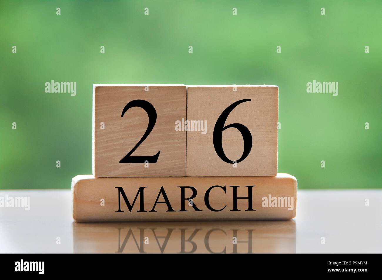 Marzo 26 testo della data di calendario su blocchi di legno con sfondo del parco sfocato. Concetto di spazio di copia e calendario. Foto Stock