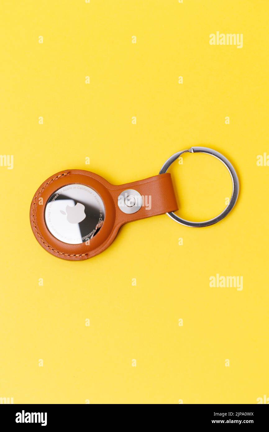 Un Apple AirTag con chainring per chiavi isolate su sfondo giallo Foto Stock