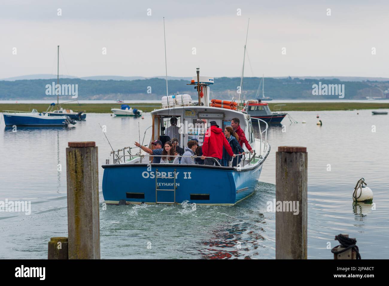 Keyhaven, Milford-on-Sea, Hampshire, Regno Unito, 16th agosto 2022, Meteo. Le docce pesanti accompagnano le nuvole scure come le cadute di pioggia necessarie su asciutto, parched l'Inghilterra del sud. Una gita di pesca parte dal molo. Credit: Paul Biggins/Alamy Live News Foto Stock