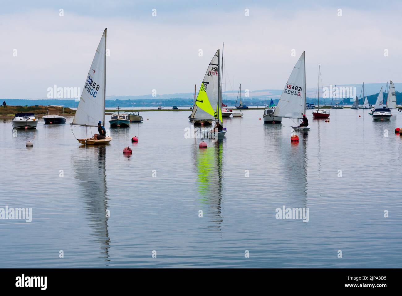 Keyhaven, Milford-on-Sea, Hampshire, Regno Unito, 16th agosto 2022, Meteo. Le docce pesanti accompagnano le nuvole scure come le cadute di pioggia necessarie su asciutto, parched l'Inghilterra del sud. Le barche a vela partono con poco vento su un laghetto di macina come un mare calmo. Credit: Paul Biggins/Alamy Live News Foto Stock