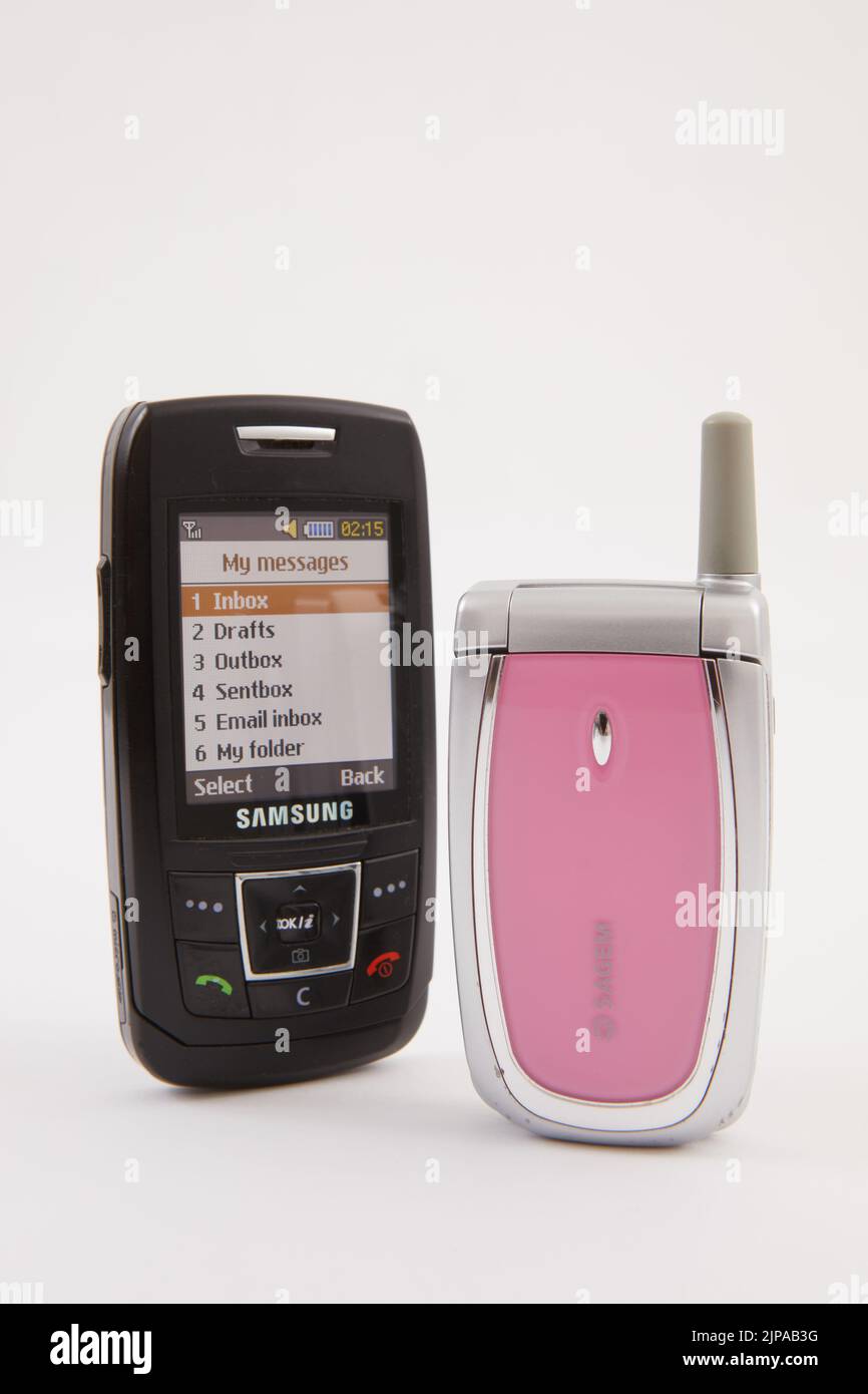 Un gruppo di telefoni cellulari retro, Motorola, Nokia, Samsung, Sagem. Fotografato su sfondo bianco. I telefoni mostrano segni di utilizzo. Foto Stock