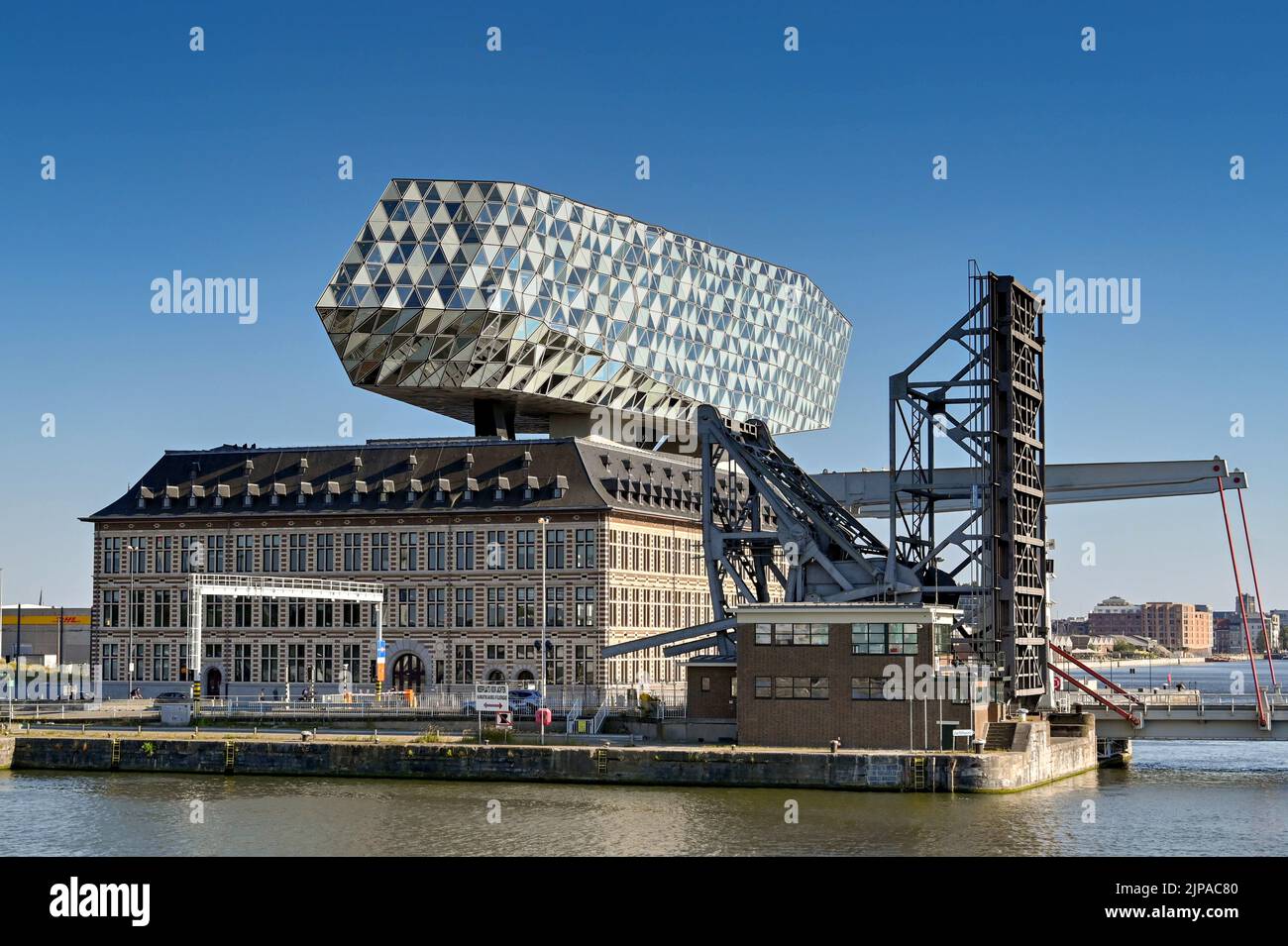 Anversa, Belgio - Agosto 2022: Esterno dell'edificio dell'autorità portuale di Anversa nelle banchine commerciali accanto al ponte di sollevamento con ponte stradale sollevato Foto Stock