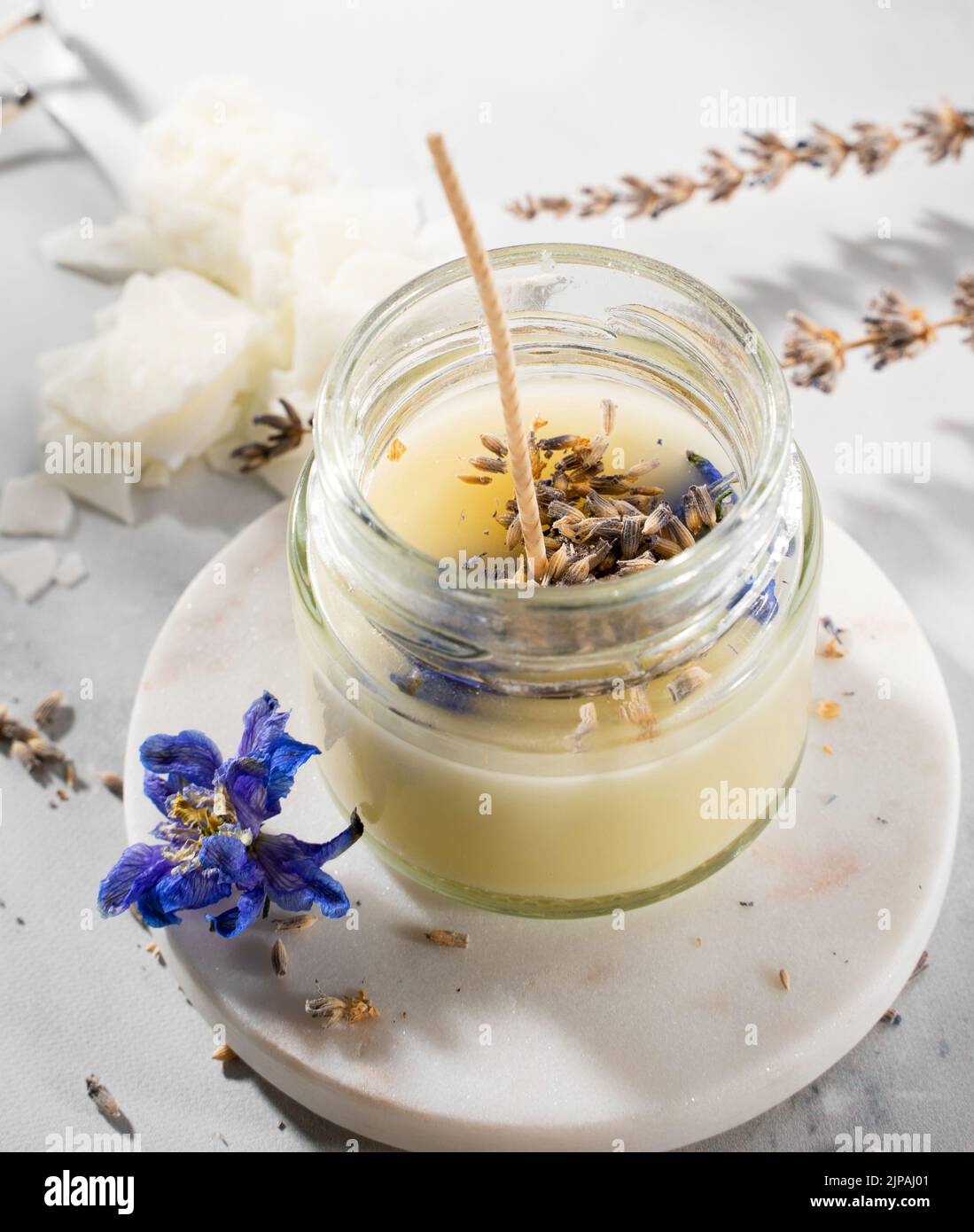 Set di strumenti per candele naturali eco-friendly di cera di soia, stoppino, profumo, olio essenziale su un tavolo di marmo. Processo di fabbricazione. Fai da te alla moda. Hobby del mestiere Foto Stock