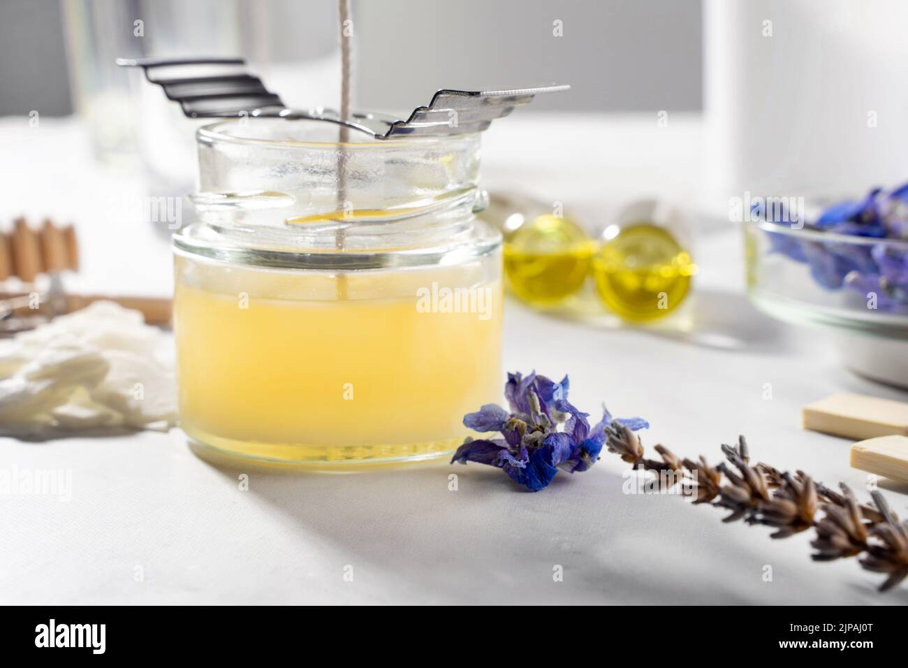 Set di strumenti per candele naturali eco-friendly di cera di soia, stoppino, profumo, olio essenziale su un tavolo di marmo. Processo di fabbricazione. Fai da te alla moda. Hobby del mestiere Foto Stock