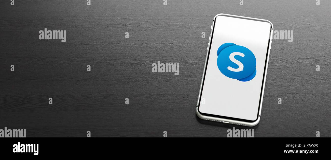 Logo del marchio della tecnologia di videoconferenza e comunicazione Skype su un telefono cellulare su un tavolo. Spazio di copia. Formato banner Web. Foto Stock