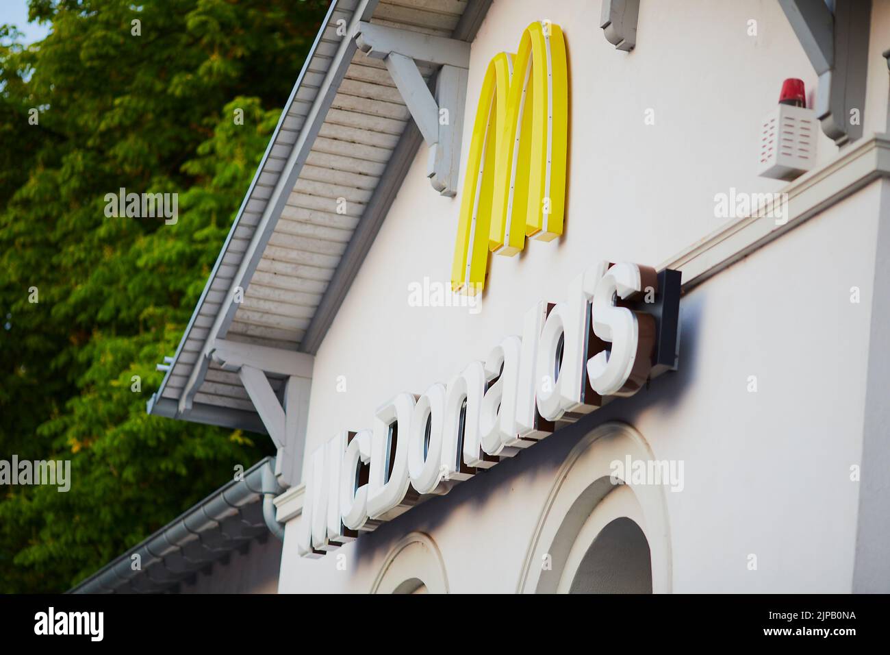Un primo piano di un cartello McDonald's su un edificio bianco Foto Stock