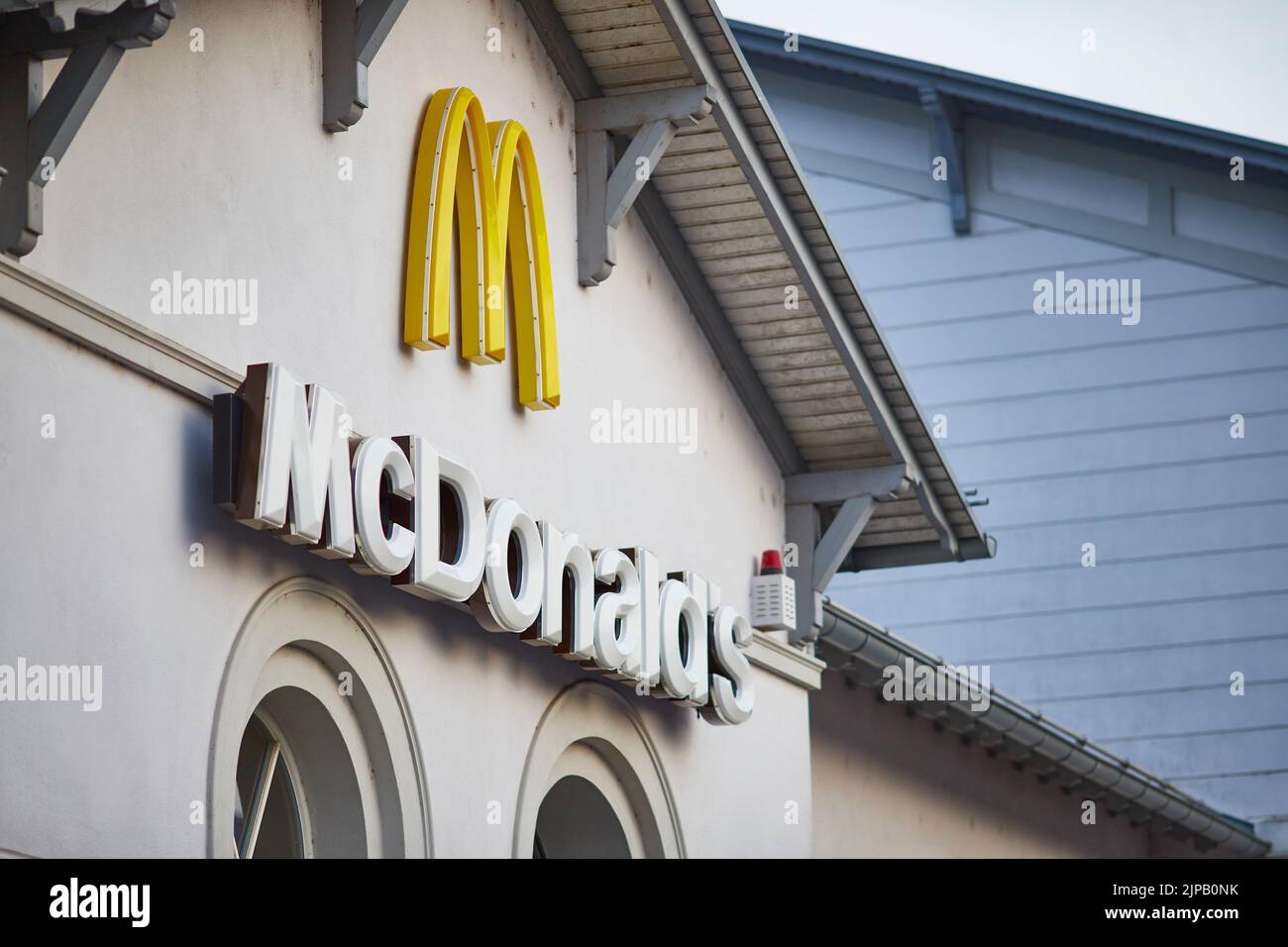 Un primo piano di un cartello McDonald's su un edificio bianco Foto Stock