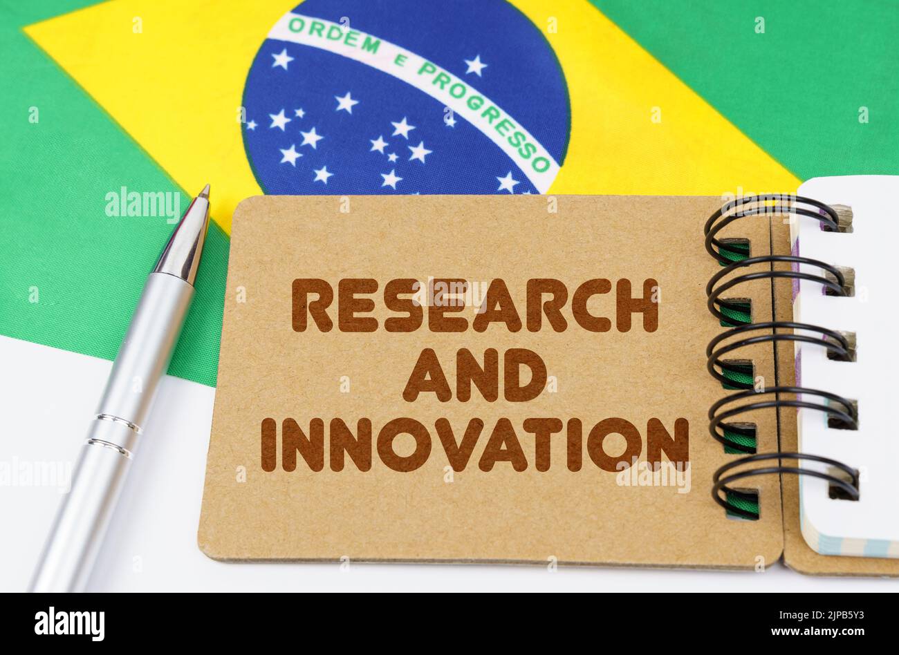 Concetto di economia nazionale. Sulla bandiera del Brasile si trova un notebook con l'iscrizione - Ricerca e innovazione Foto Stock