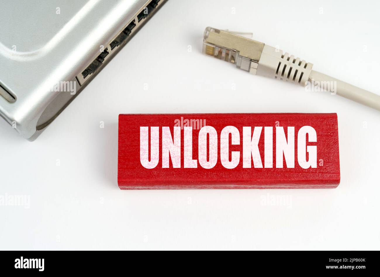 Concetto di Internet e sicurezza. C'è un router sul tavolo, disconnesso dalla rete, accanto a una targa con l'iscrizione - sblocco Foto Stock