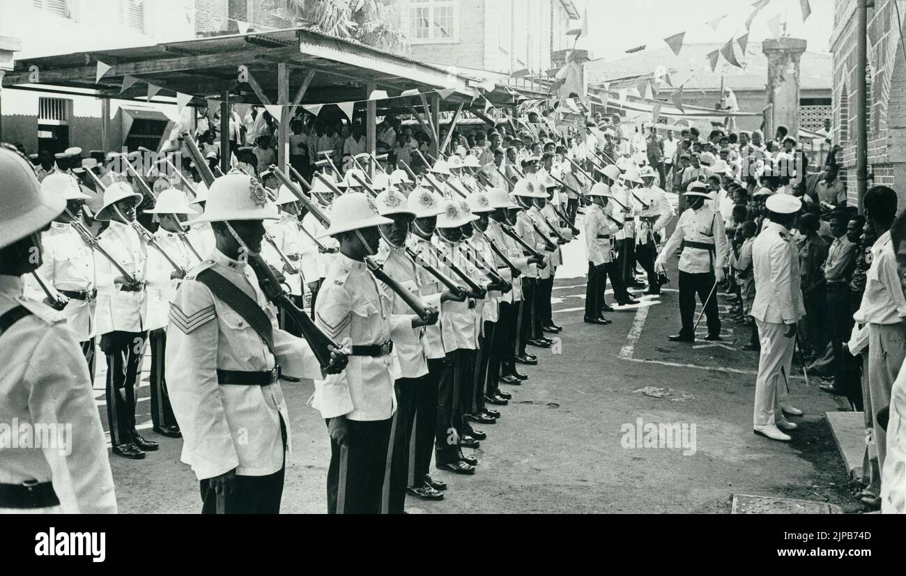 Fotografia storica in bianco e nero che mostra una sfilata di polizia in abito cerimoniale il 7 febbraio 1974, giorno dell'indipendenza di Grenada, quando divenne indipendente dal Regno Unito, Grenada, Indie Occidentali Foto Stock