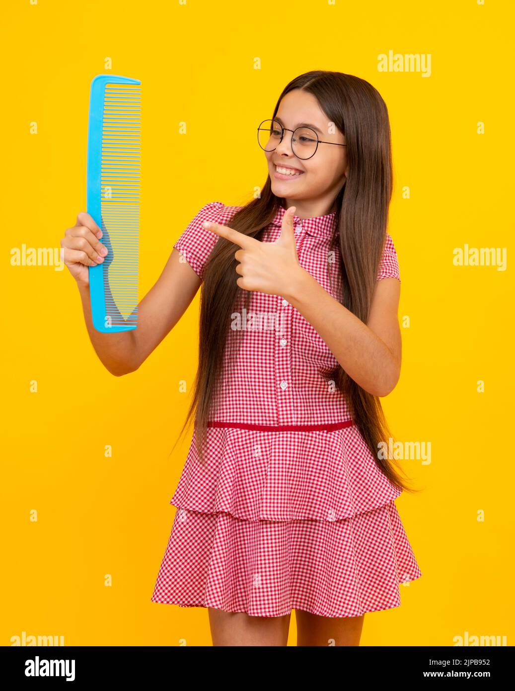 Ragazza adolescente con pettine di tenuta capelli lunghi per pettinare, bellezza. Shampoo balsamo capelli. Salone di bellezza per bambini. Acconciatura per bambini. Foto Stock