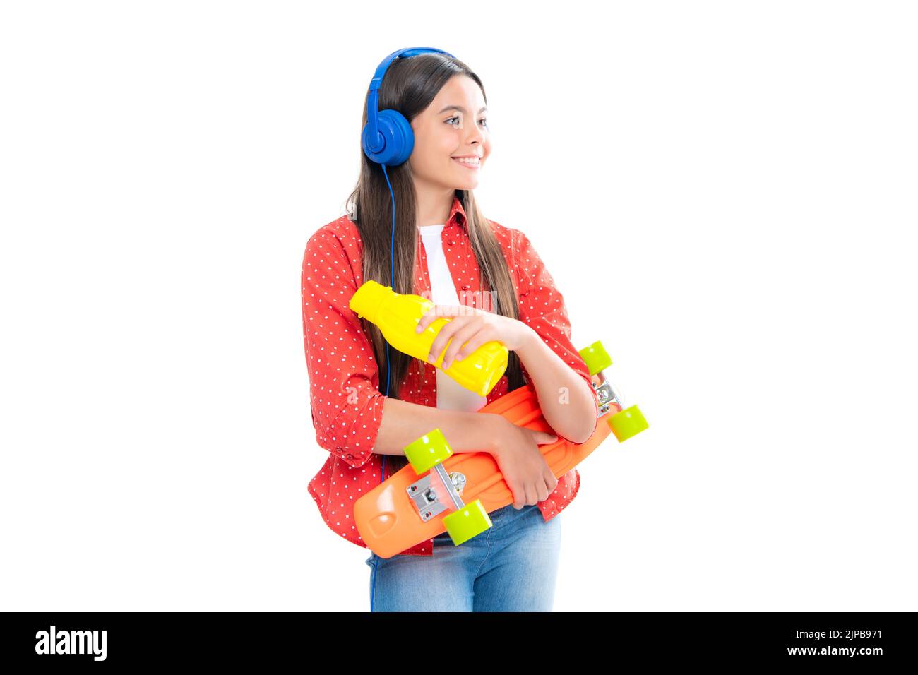 Cultura giovanile informale. Ragazza teen con skateboard su sfondo isolato studio. Adolescente in abiti alla moda. Foto Stock