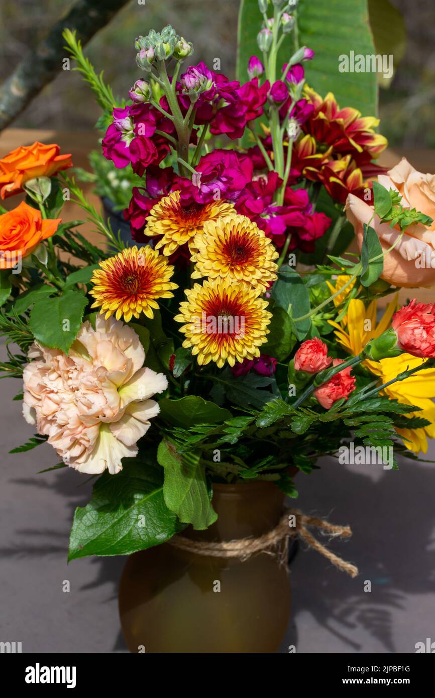 Vista ravvicinata di un bouquet di fiori colorati e luminosi in una sistemazione fiorista al coperto Foto Stock