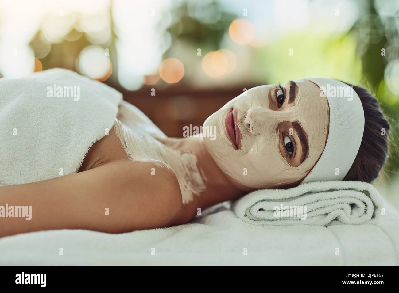 Questo è solo il mio tipo di indulgenza. Ritratto di un'attraente giovane donna che si rilassa su un tavolo da massaggio in una beauty spa. Foto Stock