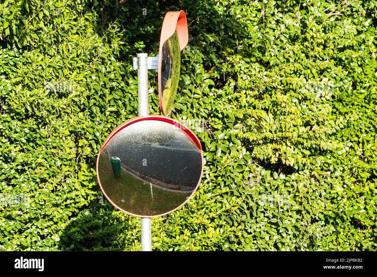 specchio convesso rotondo esterno o specchio stradale o specchio stradale ad alta visibilità montato su un palo su una strada o su una strada per la copertura dei punti ciechi Foto Stock