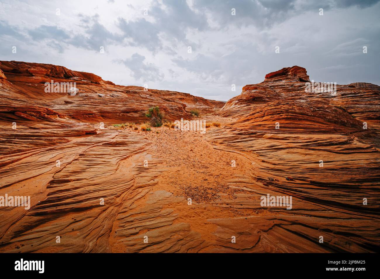 Pietre di sabbia ondulate rosse, scogliere e Clifs presso la Glen Canyon National Recriation Area, Page, Arizona, e un suggestivo sfondo di cielo nuvoloso Foto Stock