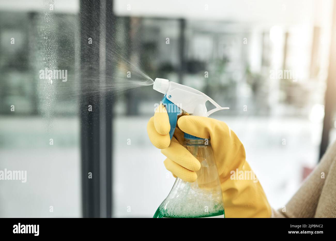 Pulisca, lavi e le faccende di giorno nel paese con un flacone di igiene domestica per le finestre all'interno. Primo piano del lavoro di pulizia, lavaggio e mano di lavoro con Foto Stock