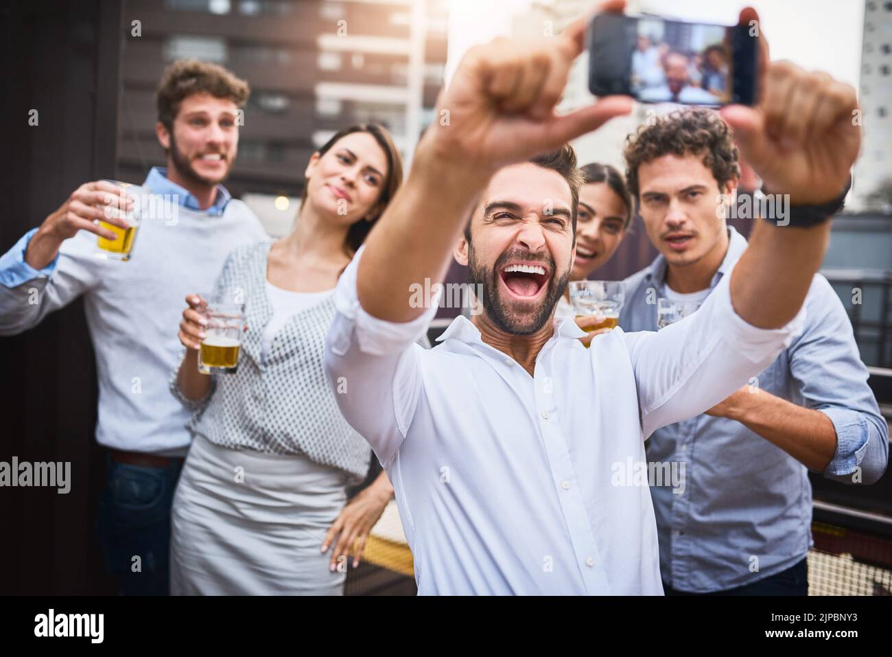 Festeggiamo la nostra settimana di successo. Gli uomini d'affari bevono un drink sul balcone dell'ufficio. Foto Stock