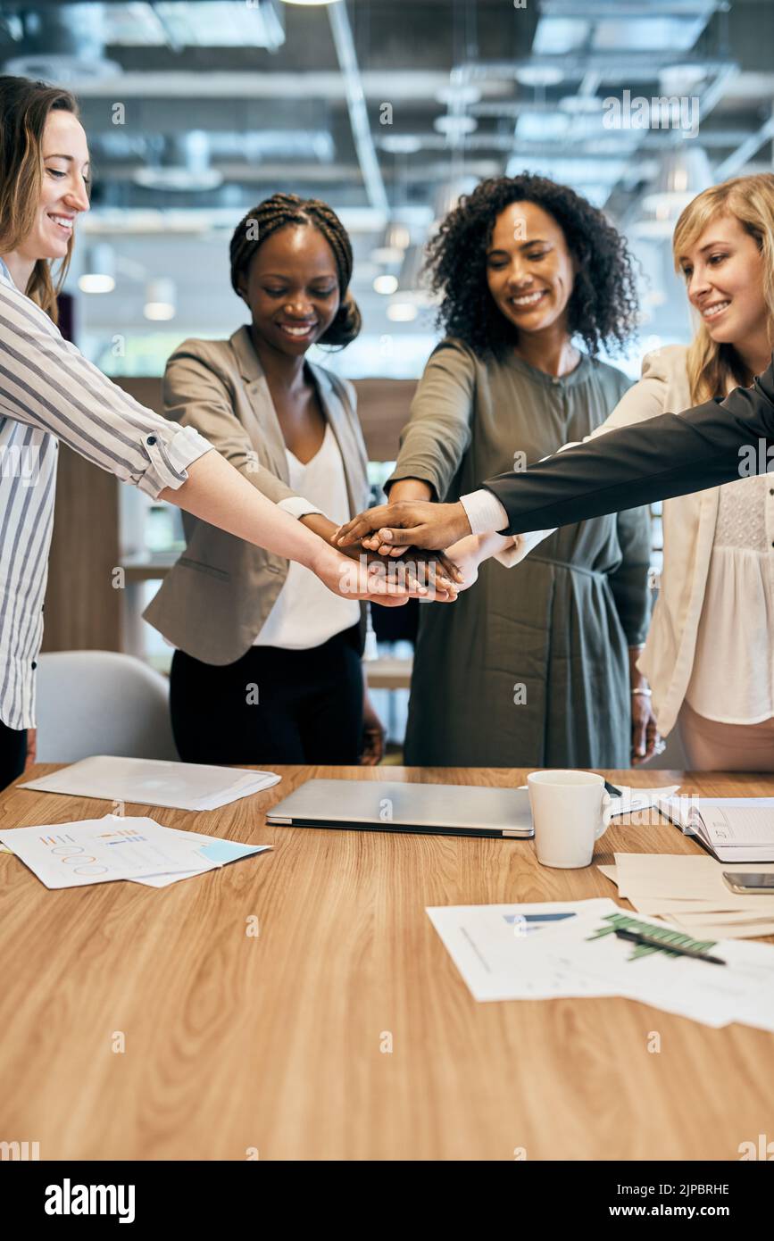 Abbiamo avuto questi ragazzi. Un gruppo allegro di uomini d'affari che formano un huddle con le mani all'interno dell'ufficio durante il giorno. Foto Stock