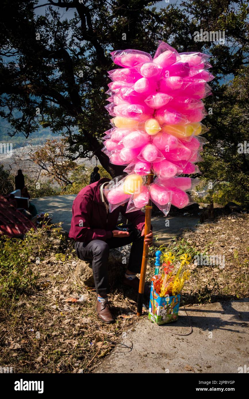Febbraio 13th 2022. Dehradun Uttarakhand India. Un uomo che vende caramelle colorate di cotone in una fiera durante una stagione di festival in India. Foto Stock