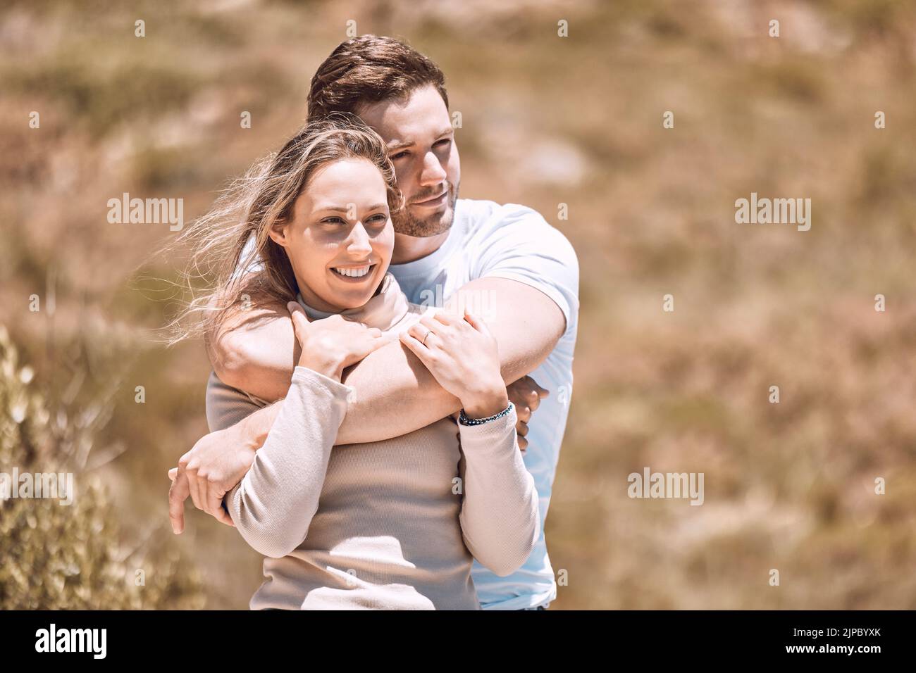 Amore, romanticismo e incontri con una giovane coppia affettuosa abbracciando, legando e trascorrendo il tempo insieme all'esterno. Uomo felice, amorevole e sorridente e. Foto Stock