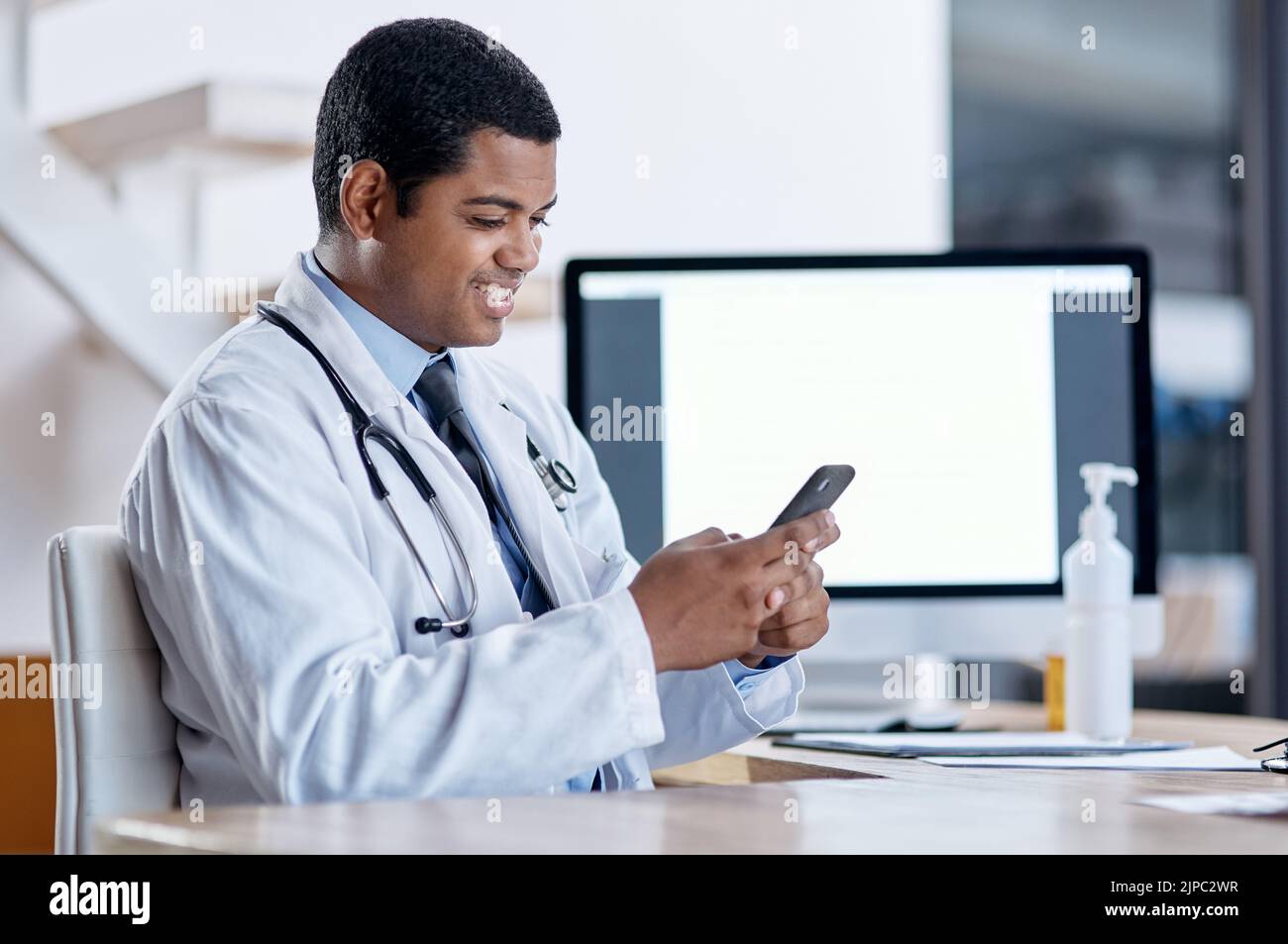 Consulenza medica con un paziente online su videochiamata al telefono, facendo telemedicina e ascoltando durante un appuntamento medico. Felice, sorridente Foto Stock