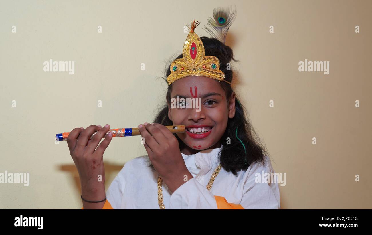 Felice Janmashtami piccolo ragazzo indiano in posa come Shri Krishna o kanha o kanhaiya con flauto. Foto Stock
