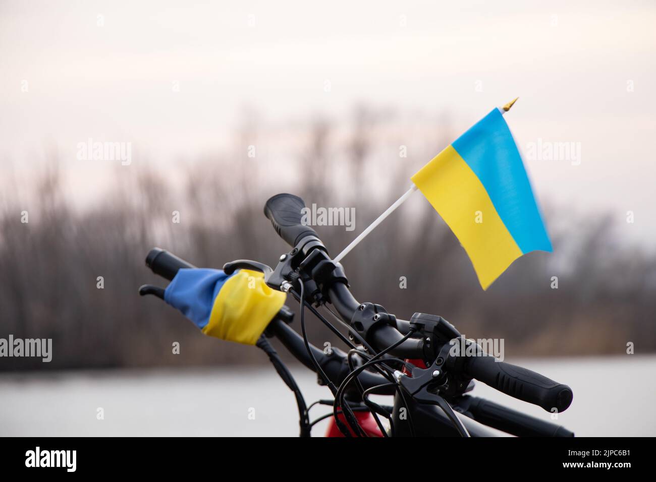 Bandiera giallo-blu dell'Ucraina su una bicicletta in una città in Ucraina, un'azione di protesta, fermare la guerra in Ucraina, un patriota del suo paese 2022 Foto Stock