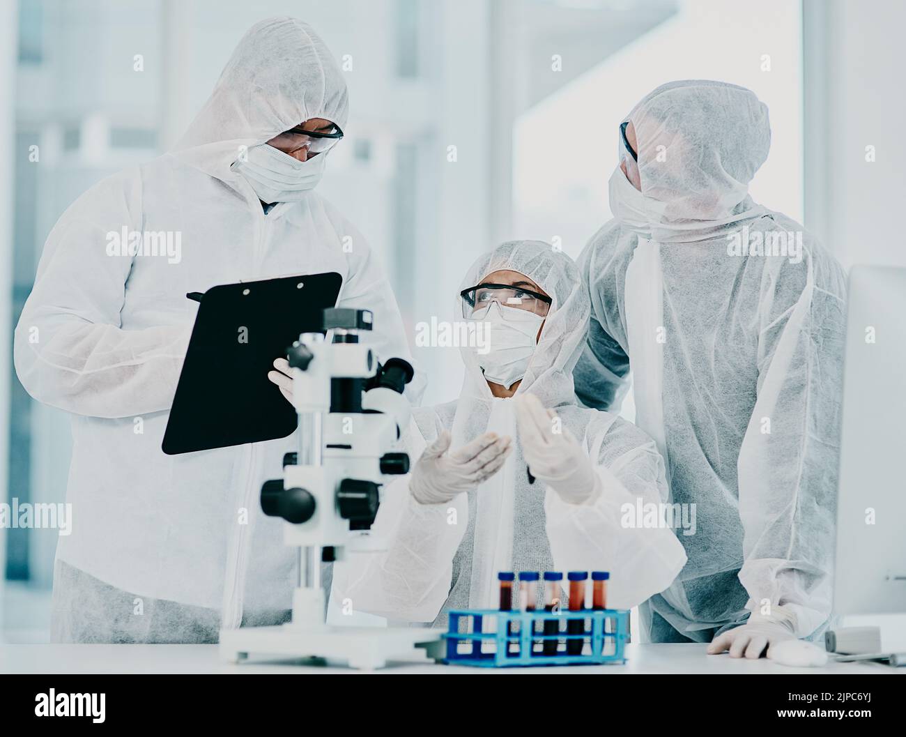 Scienza e medici di ricerca che lavorano sul vaccino covid test mentre indossano tute di protezione in medicina moderna laboratorio. Gruppo di Foto Stock