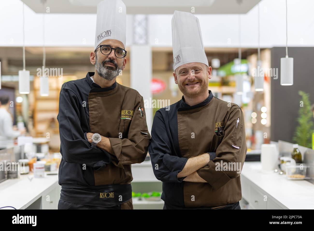 Due chef dietro il loro tavolo. Al ristorante. Foto Stock