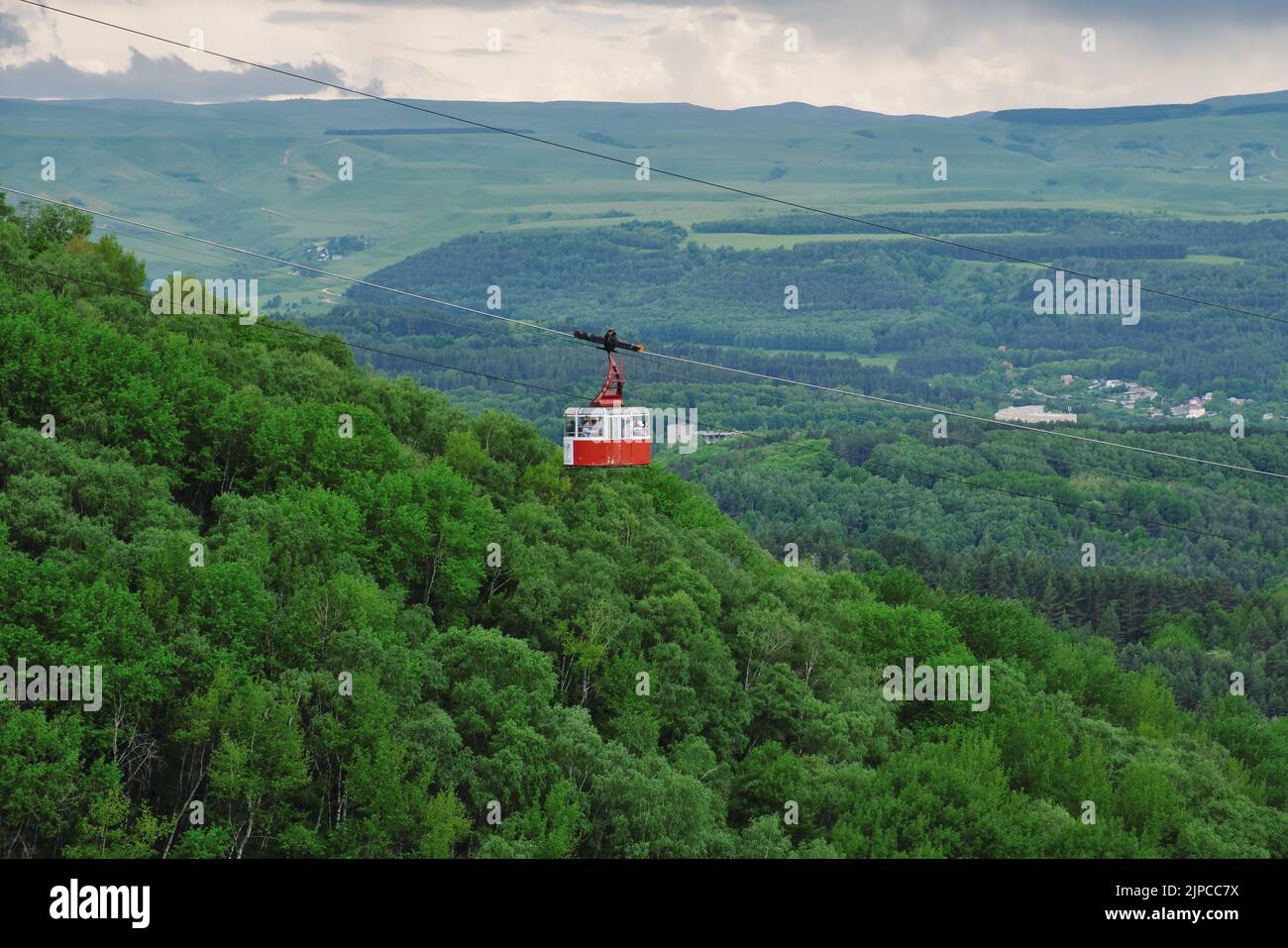 Cabina rossa della funivia sopra la foresta. Cabina funicolare sulle verdi colline. Parco nazionale di Kislovodsk, Russia. Foto Stock