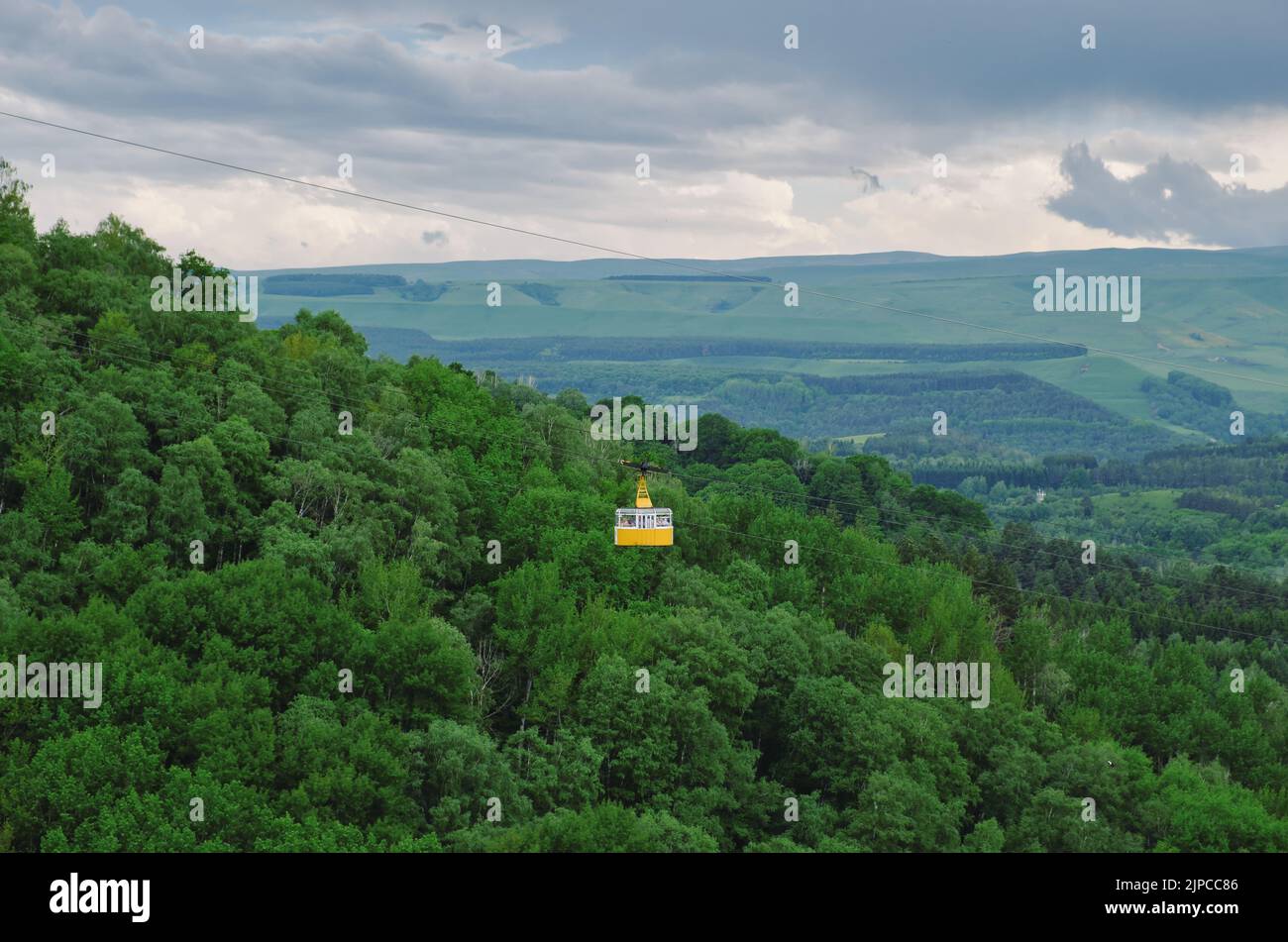Cabina gialla della funivia sopra la foresta. Cabina funicolare sulle verdi colline. Parco nazionale di Kislovodsk, Russia. Foto Stock