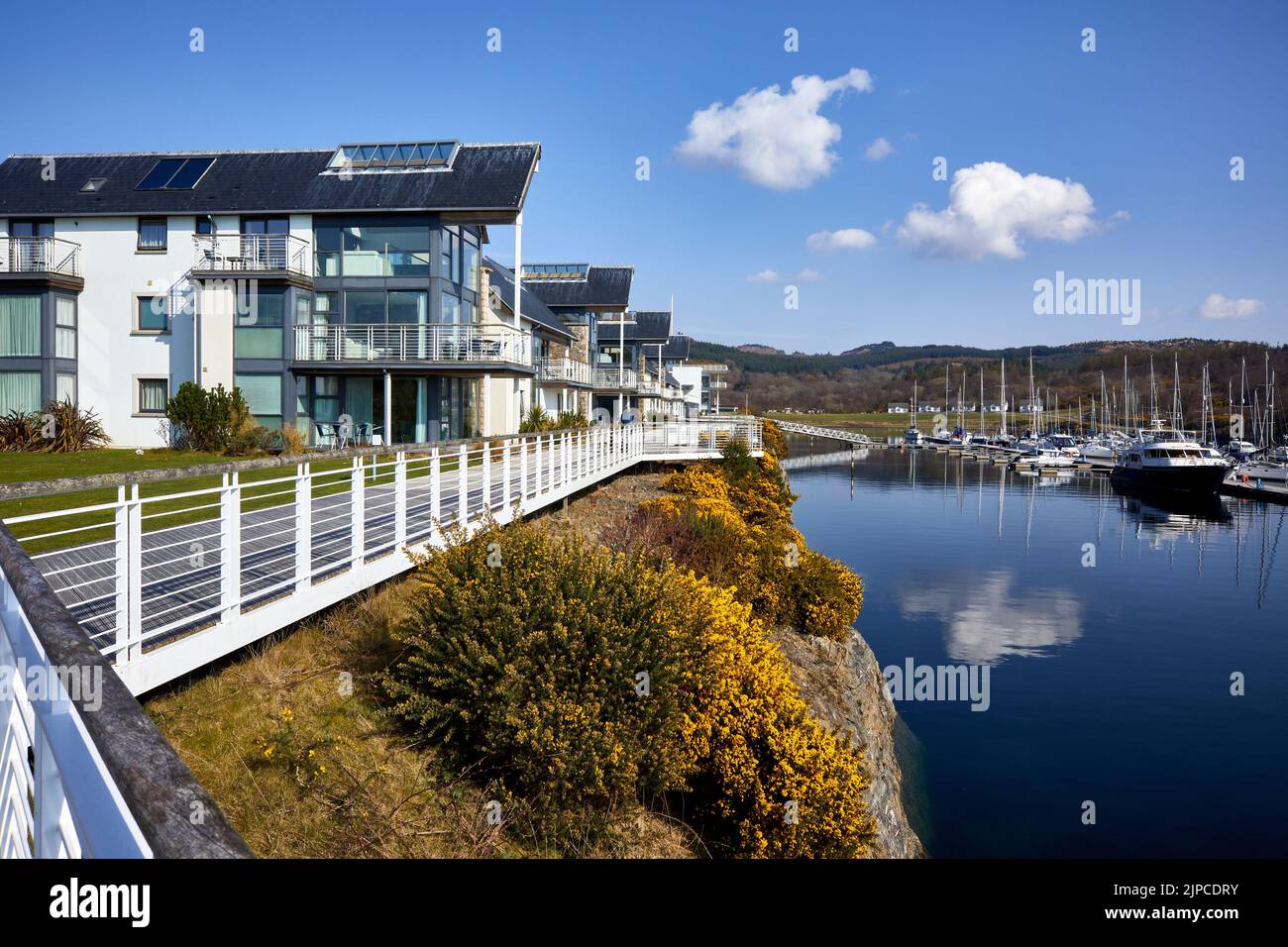 Affacciato sul porto, l'alloggio si trova in una luminosa e tranquilla mattina di marzo, gli ormeggi nella Marina di Portavadie. Loch Fyne Foto Stock