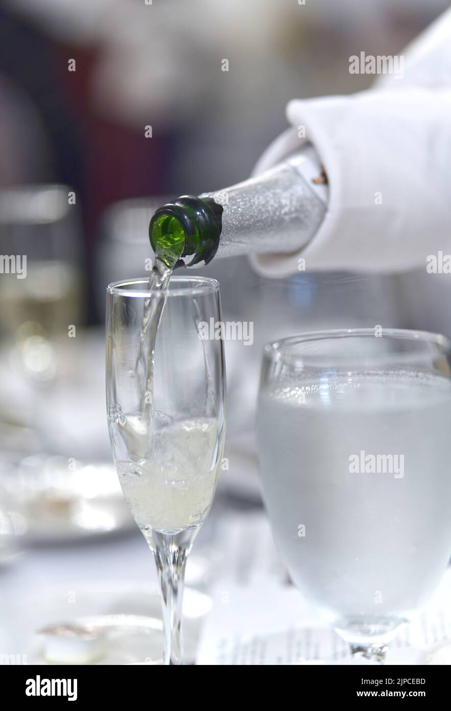 Champagne che si riversa in un bicchiere nella sala banchetti di Miami, Florida. Foto Stock
