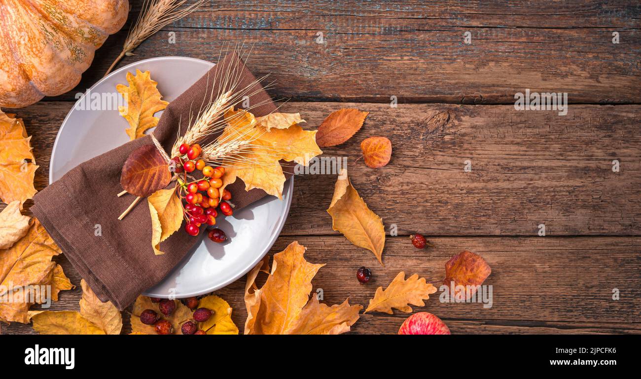 Fondo autunnale con posate e foglie autunnali su fondo ligneo. Foto Stock