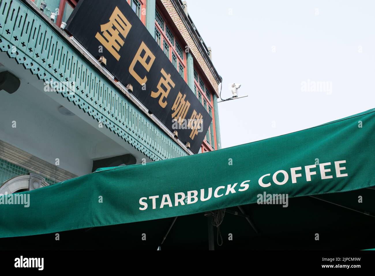 Caffetteria Starbucks, insegna scritta in cinese e inglese - Qianmen Street, Pechino. Foto Stock
