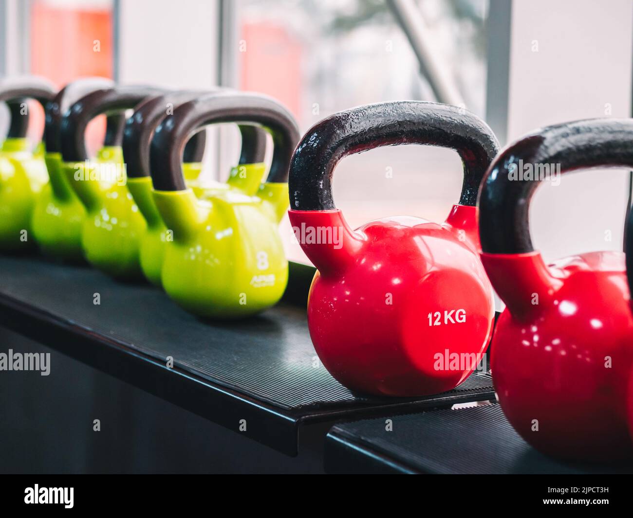 File di manubri pesanti in metallo su rack in palestra o club. Attrezzature per l'addestramento al peso. Concetto di sport e salute. Foto Stock