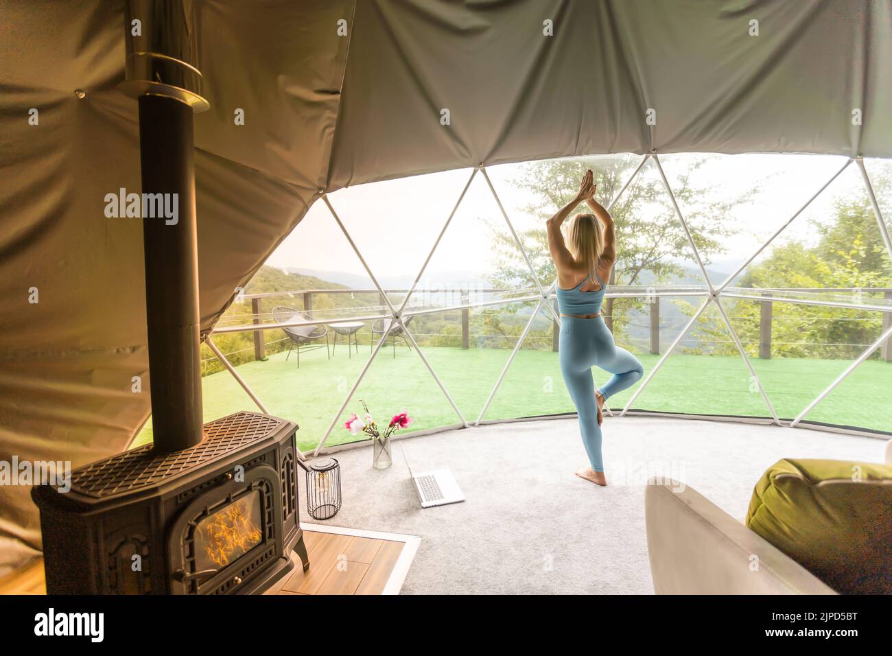 Donna sportiva che fa esercizio in una tenda glamping geo dome Foto Stock