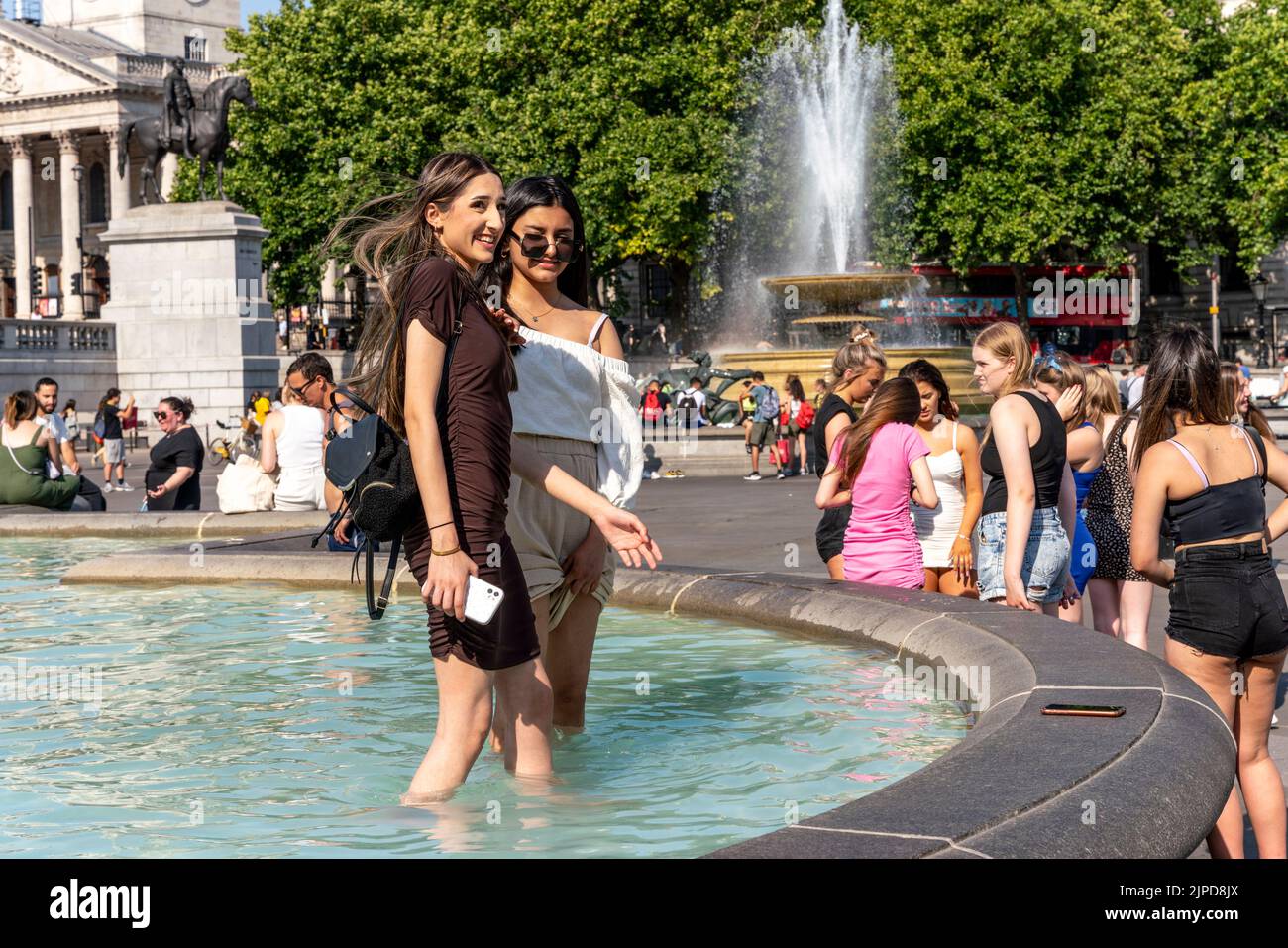I giovani si raffreddano nelle fontane di Trafalgar Square durante il giorno più caldo mai registrato nella capitale, Londra, Regno Unito. Foto Stock