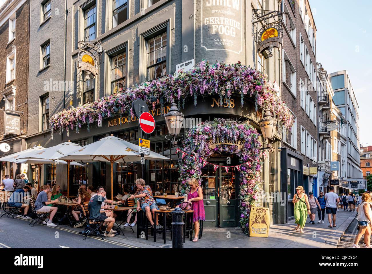 Persone sedute fuori dalla Taverna Fogg's a St Martin's Lane, Londra, Regno Unito. Foto Stock