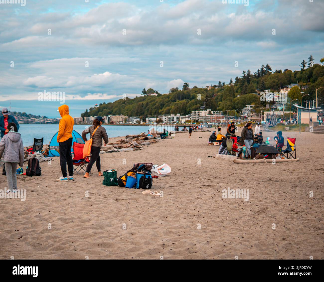 Un gruppo di persone che riposano sulla bellissima spiaggia sabbiosa di Alki a Seattle Foto Stock