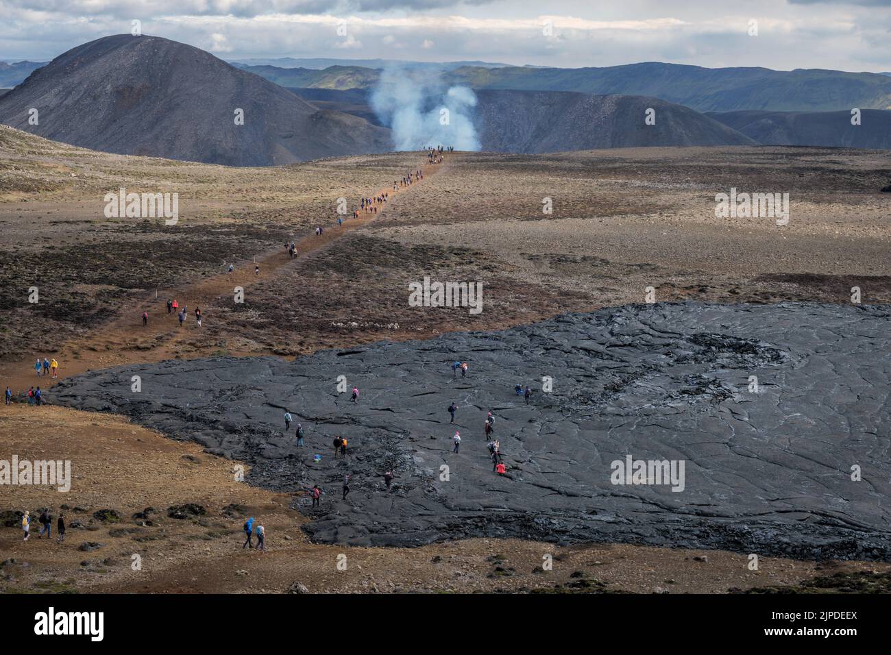 Escursionisti che passano il vecchio campo di lava sulla strada per l'eruzione del vulcano Meradalir, penisola di Reykjanes, Islanda, agosto 2022. Foto Stock