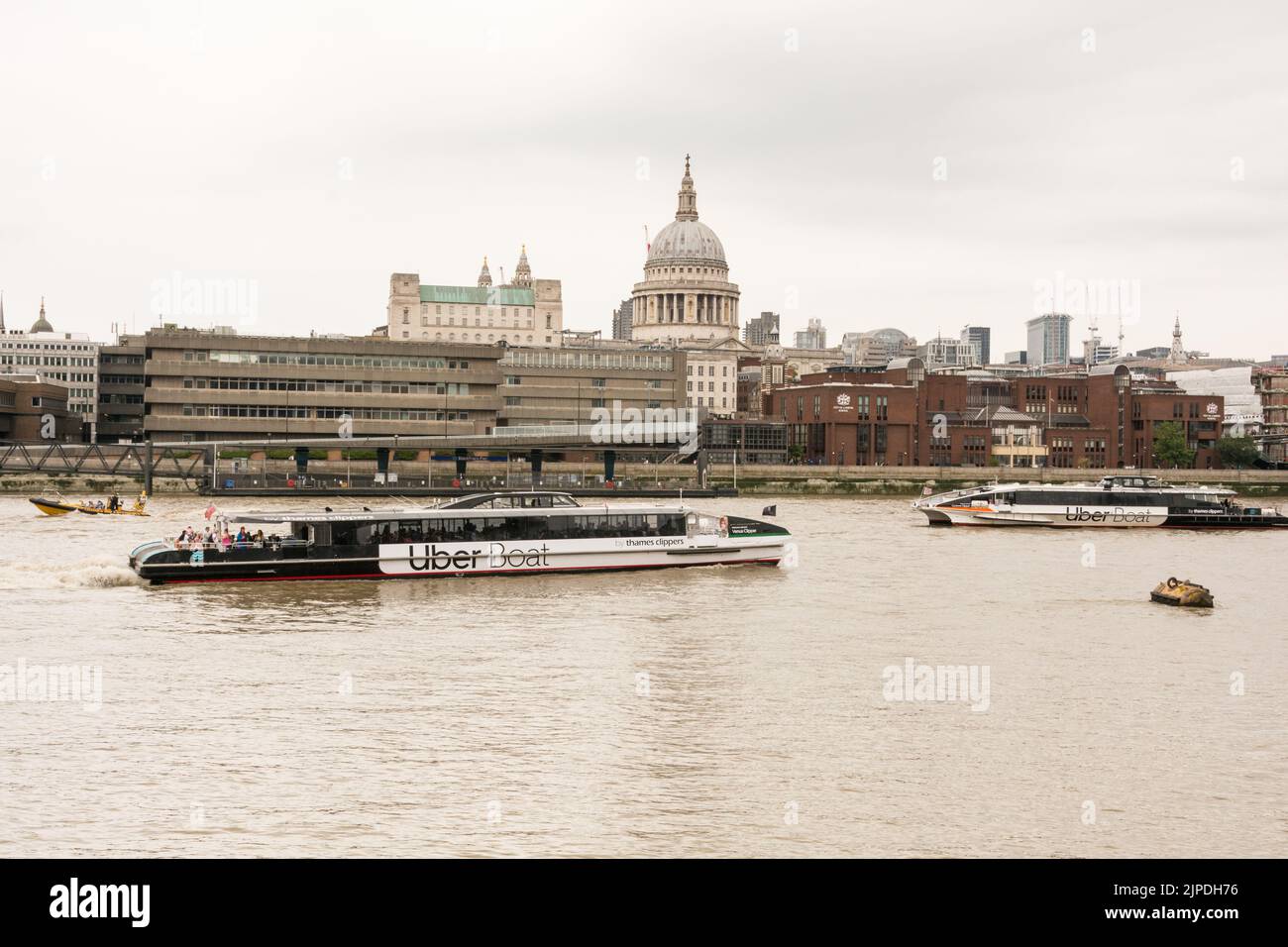 Due barche Uber che passano davanti alla Cattedrale di St Paul e alla City of London School sulla northbank del Tamigi, Londra, Inghilterra, Regno Unito Foto Stock