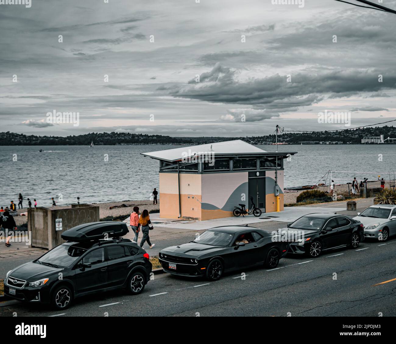 Una splendida vista delle auto parcheggiate accanto ad Alki Beach in una giornata buia a Seattle Foto Stock